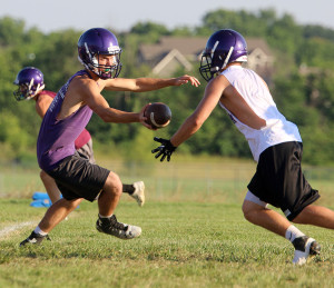 Quarterback Austin Terry hands off to a Wildcat running back Friday during the team's final day of camp.
