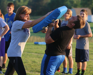 Janie Dunn shows her son, Alex, how hard she can hit during the mom's portion of the camp Friday evening.