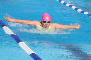 Maddie Kelly swims toward the wall in the 50-meter butterfly against Woodson on Saturday in Louisburg.