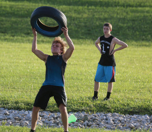 Nathan Keegan throws a tire over his head last week during a strongman workout.