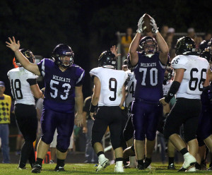 Mason Koechner (53) signals Louisburg ball while T.J. Dover holds the ball up after he recovered a fumble Friday in Louisburg.