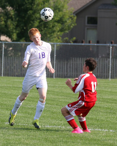 Defender Scott Murphy heads the ball away from a Fort Scott player Tuesday in the Wildcats' season opener in Louisburg.