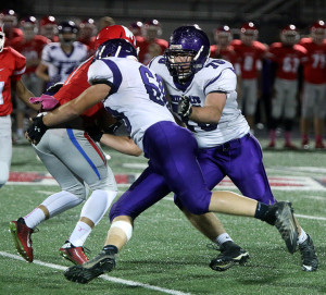 Louisburg juniors Dustyn Rizzo (left) and T.J. Dover team up for a sack on Bishop Miege quarterback Carter Putz   on Friday at Bishop Miege High School.