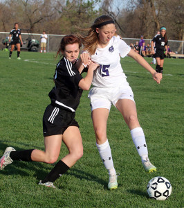 Junior Lily Cook (right) tries to hold off a Piper defender Tuesday in Louisburg. 