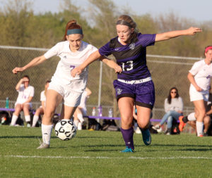 Louisburg's Madisen Simpson (right) tries to fight off a Spring Hill player to win a 50-50 ball Thursday.
