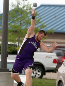 Senior Jarod Woodward lifts the shot put into the air during Friday's regional track meet in Chanute.