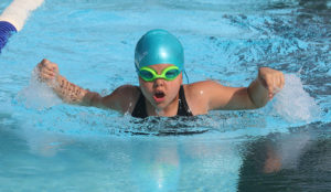 Jesse Faulker swims the butterfly during the June 11 meet in Harrisonville. Faulkner won four first-place ribbons.