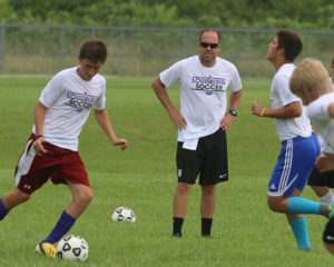 Head coach Kyle Conley looks on as his players go through a drill during the Wildcats' team camp earlier this month.