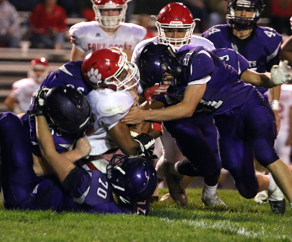 Austin Moore (21) leads a host of Wildcats tacklers as they bring down a Fort Scott player Friday in Louisburg