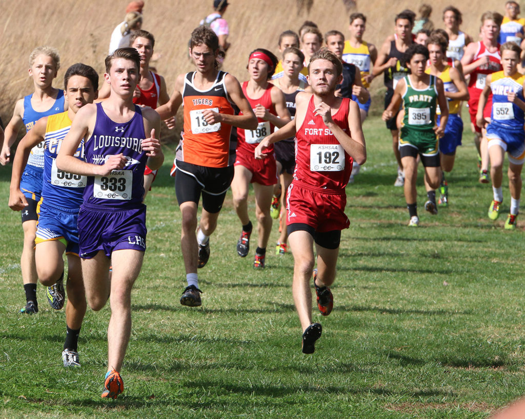 Louisburg junior Wyatt Reece runs with a large group of runners downhill Saturday in Wamego.