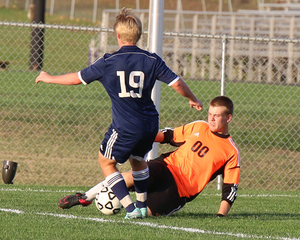 Louisburg goalie Ambrose Stefan slides in for one of his many saves Tuesday in the state quarterfinals in Louisburg.