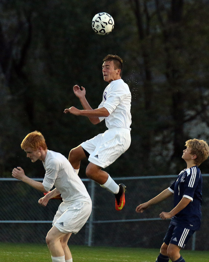 Junior defender Kris Light heads the ball away during Tuesday's state quarterfinal match against Trinity.